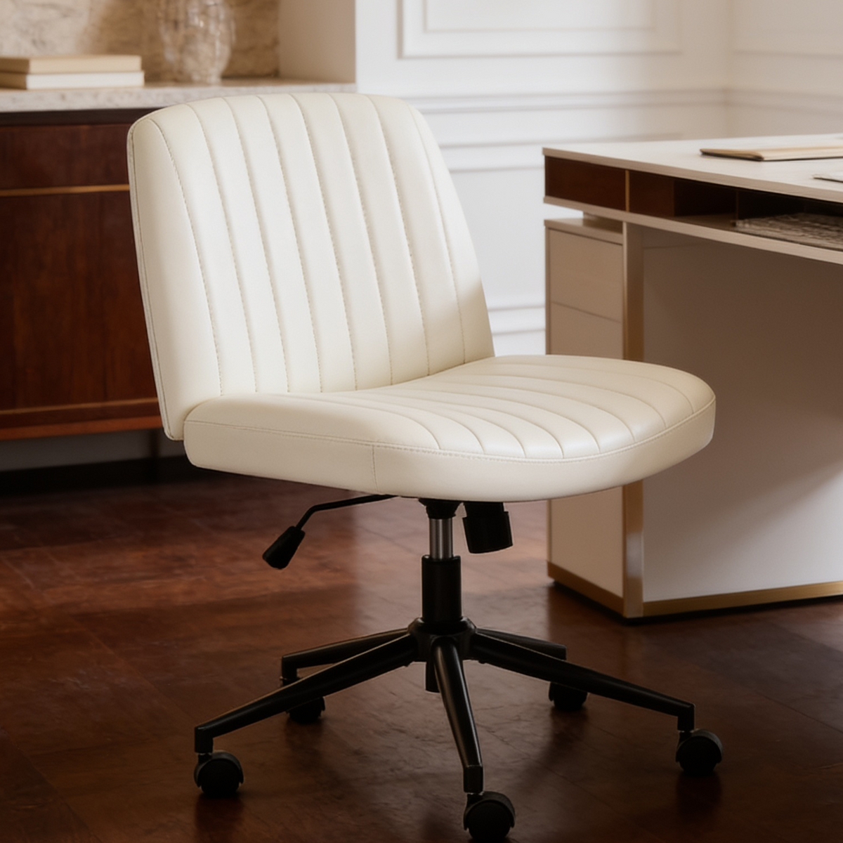 Cream armless swivel desk chair with channel stitched back beside a desk