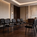 Row of black leather guest chairs lined along a waiting room wall