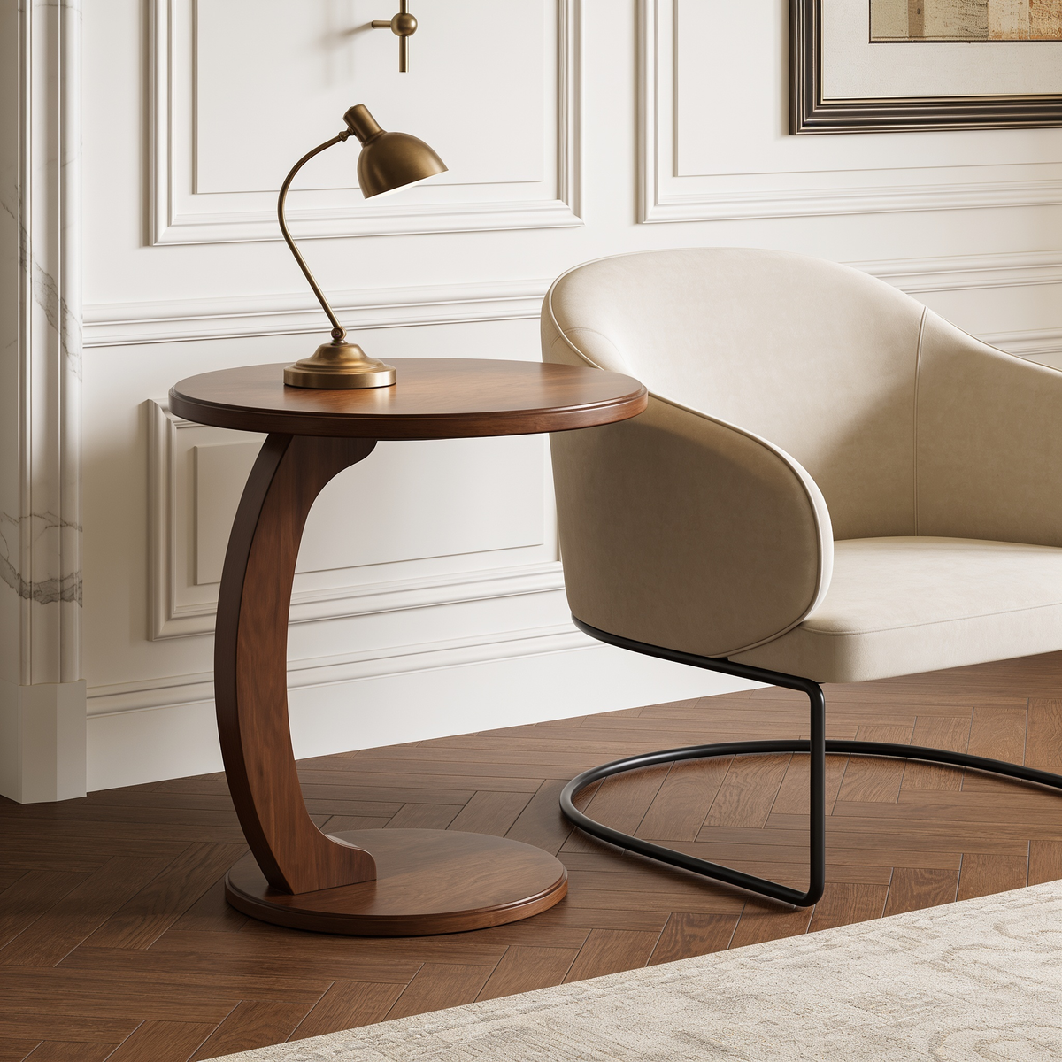 Round walnut side table with curved crescent base holding a brass lamp by a chair