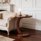 Curved base side table beside a cream sofa with a small lamp and a closed book
