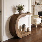 Wood console with a leafy plant on top and pale vases on the floor below