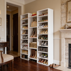 Freestanding shoe shelf full of shoes in a room with a fireplace and armchair