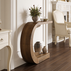 Curved console along a hallway wall with vases on the floor and a chair beyond