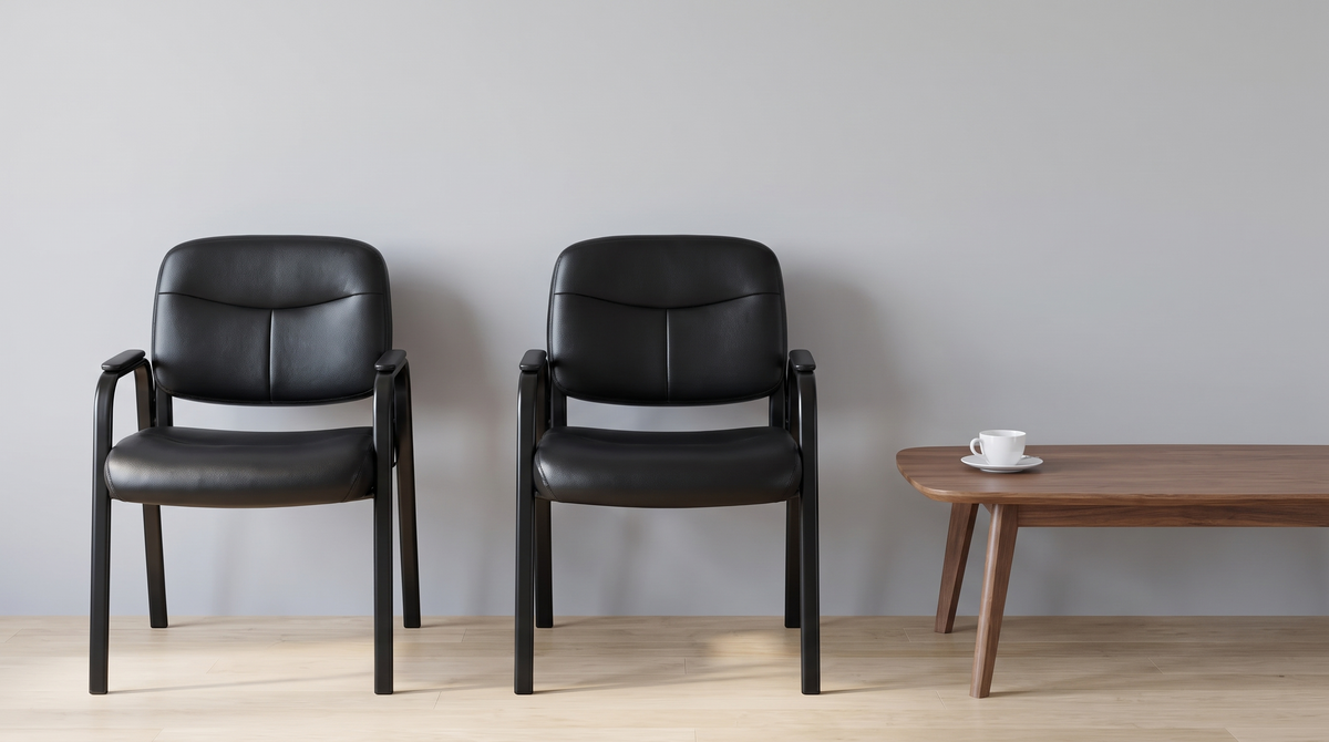 Two black padded guest chairs in a reception area