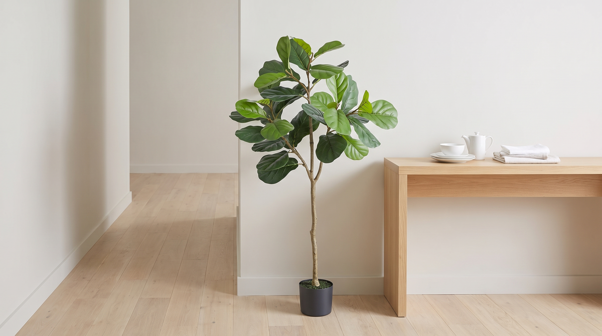 Faux tulip tree with broad leaves beside a hallway console