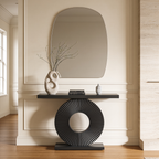 Black fluted disc console under an arched mirror with a sculptural vase of branches