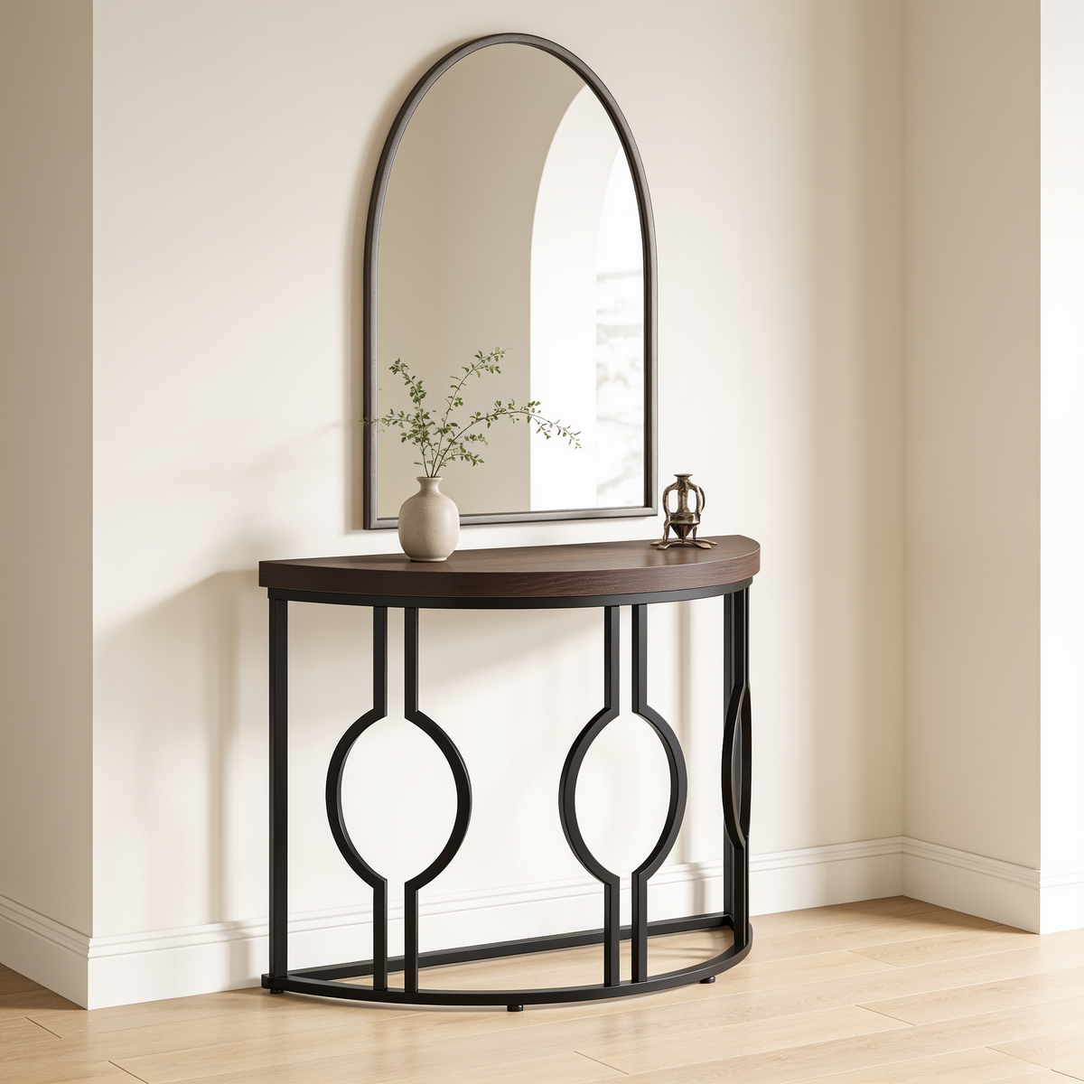 Half moon console styled with a vase of stems below an arched mirror on a white wall