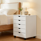 White five drawer bedside cabinet beside a wood bed with a lamp and plant on top
