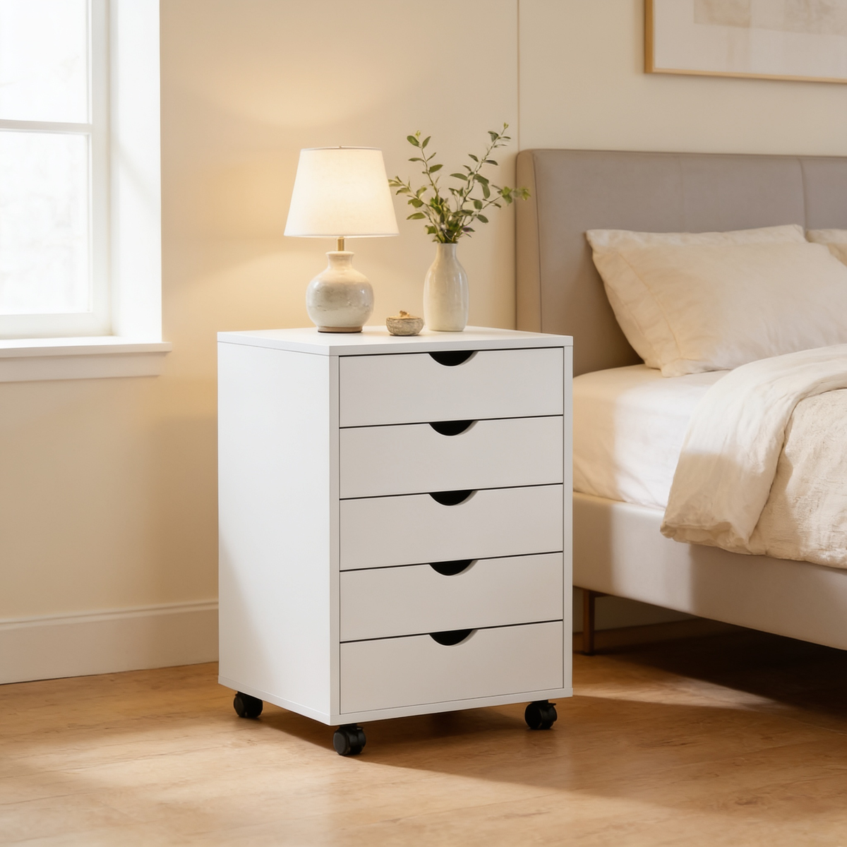Rolling drawer cabinet next to a gray upholstered headboard beneath a window