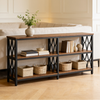 Sofa table stacked with baskets and books, a vase of stems on the top shelf