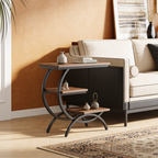 Walnut and black side table on a patterned rug next to a sofa in a warm toned room