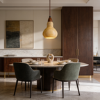 Carved stone gourd pendant glowing above a round dining table with green chairs