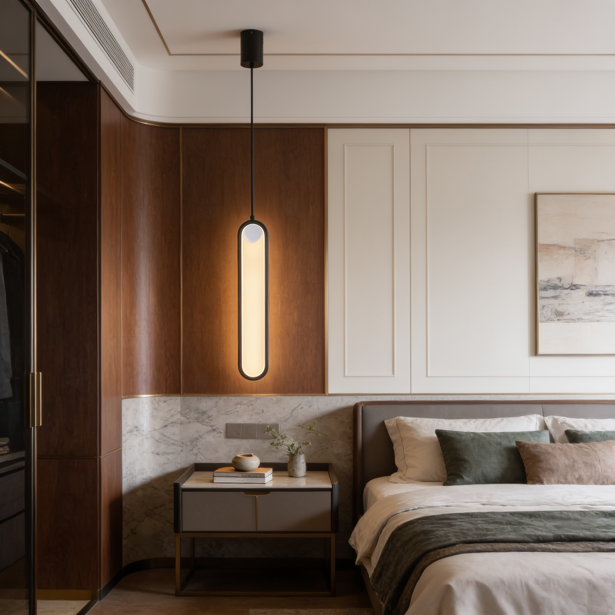 Slim lit loop pendant hanging over a dark nightstand in a cream and marble bedroom