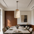 Travertine pendant lit over a marble table against warm wood paneling