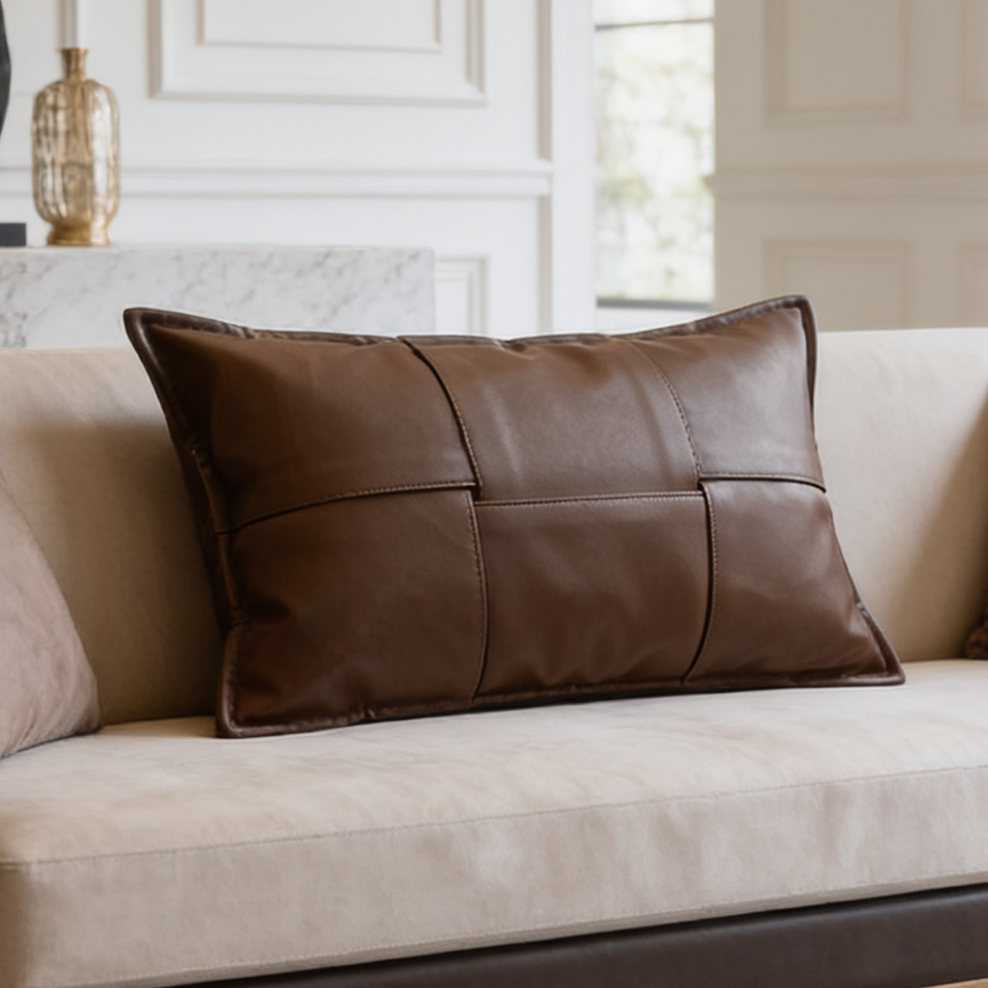 Brown stitched panel lumbar cushion centered on a long cream sofa by a paneled wall