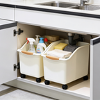 Beige bins on black casters standing on a cabinet floor below a double sink