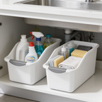 Close view of two white pull out bins loaded with sprays a sponge and a towel