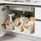 Cream bins with orange grips rolled into an under sink cabinet seen from the side