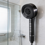 Front view of the black sprayer running in a bright tiled shower