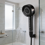 Black shower head resting in its wall bracket inside a glass shower