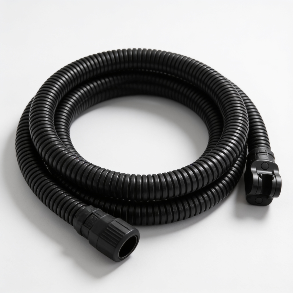 Coiled black shower hose with its brass connector on a white surface