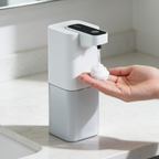 Touchless pump dropping a foam dome into an open palm on a stone counter