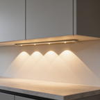 Under cabinet bar casting scalloped pools of warm light on a stone counter