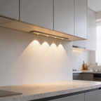 Light bar lighting a marble counter under upper cabinets in a bright kitchen