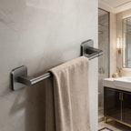 Black towel rail holding a white towel on a tiled wall beside a lit vanity
