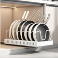 Cabinet rack holding stacked pans and lids upright behind an open door