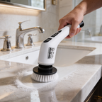 Hand guiding the cordless spin scrubber across a marble bathroom countertop