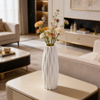 White ribbed vase of yellow blooms on a table in a living room