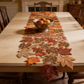 Embroidered maple leaf table runner with cut out edges on a wooden dining table