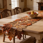 Maple leaf runner on a dining table beside a bowl of fruit