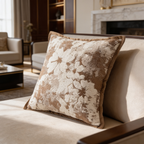 Taupe cushion with a large cream botanical jacquard propped on a sofa cushion