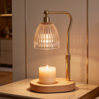 Head on view of the warmer lamp above a lit white pillar candle