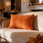 Orange lumbar pillow cover quilted with pumpkin shapes on a neutral sofa