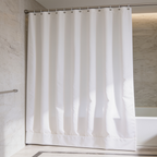 White bath curtain with a weighted hem pulled shut in front of a soaking tub