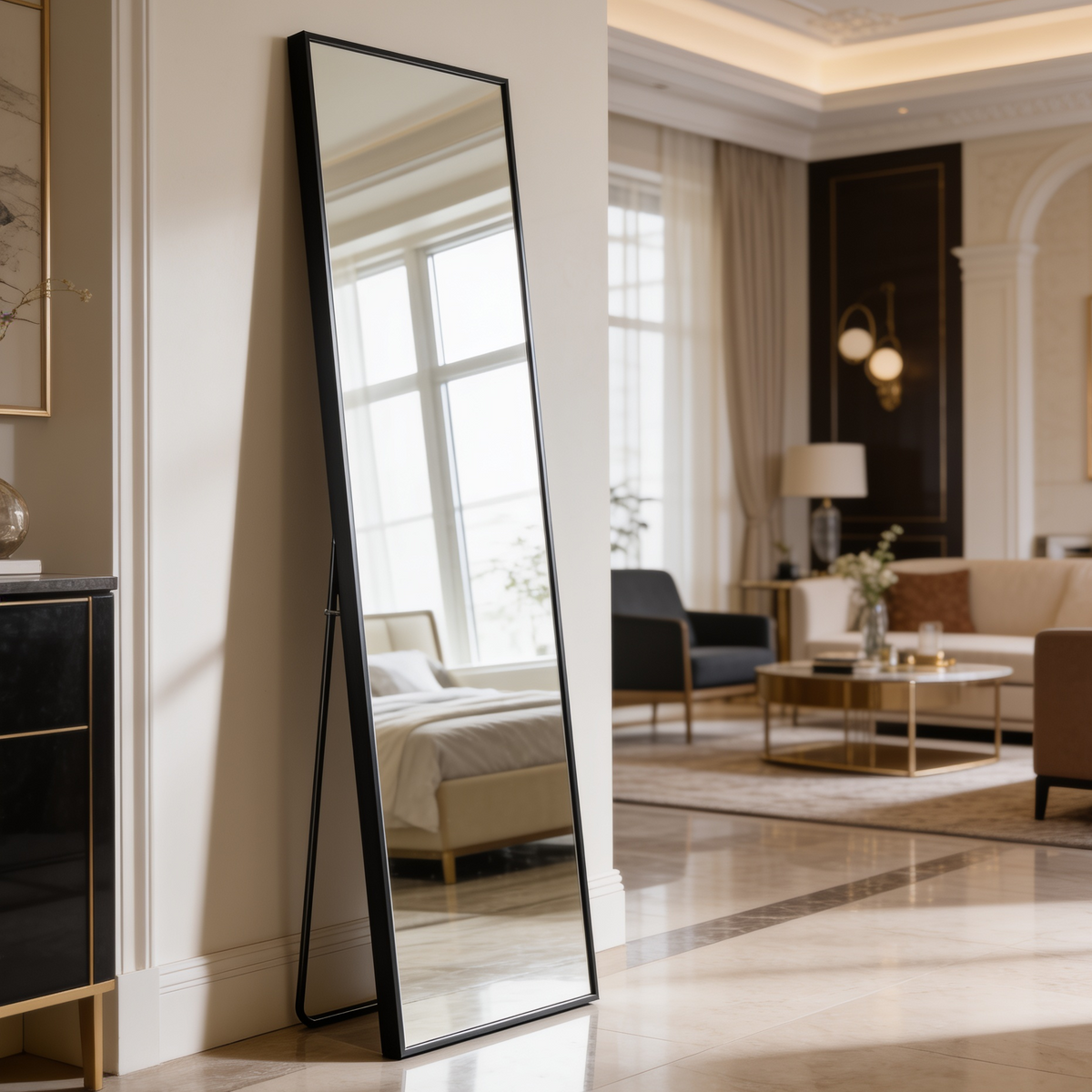 Black framed standing mirror on a marble floor, reflecting an armchair and window