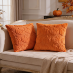 Two orange quilted pumpkin pillows, one square and one lumbar, on a beige couch
