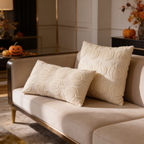 Cream quilted ghost pillows side by side on a beige sofa with pumpkins behind