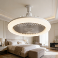 Ceiling fan light glowing on a bedroom ceiling above the bed