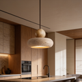 Wide flat stone pendant lighting a wooden counter and cabinets