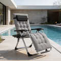 Gray cushioned recliner laid back by a pool with a cup holder tray attached