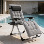 Gray cushioned zero gravity chair reclined at the edge of a swimming pool