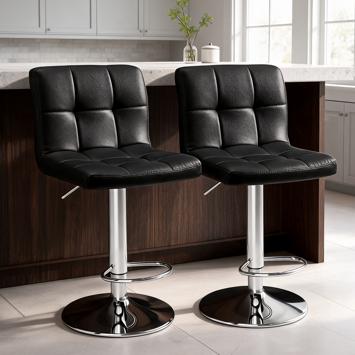 Two black tufted bar stools with chrome bases pulled up to a pale kitchen island