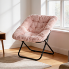 Pink faux fur saucer chair with a folding metal frame on a wood floor near a bright window