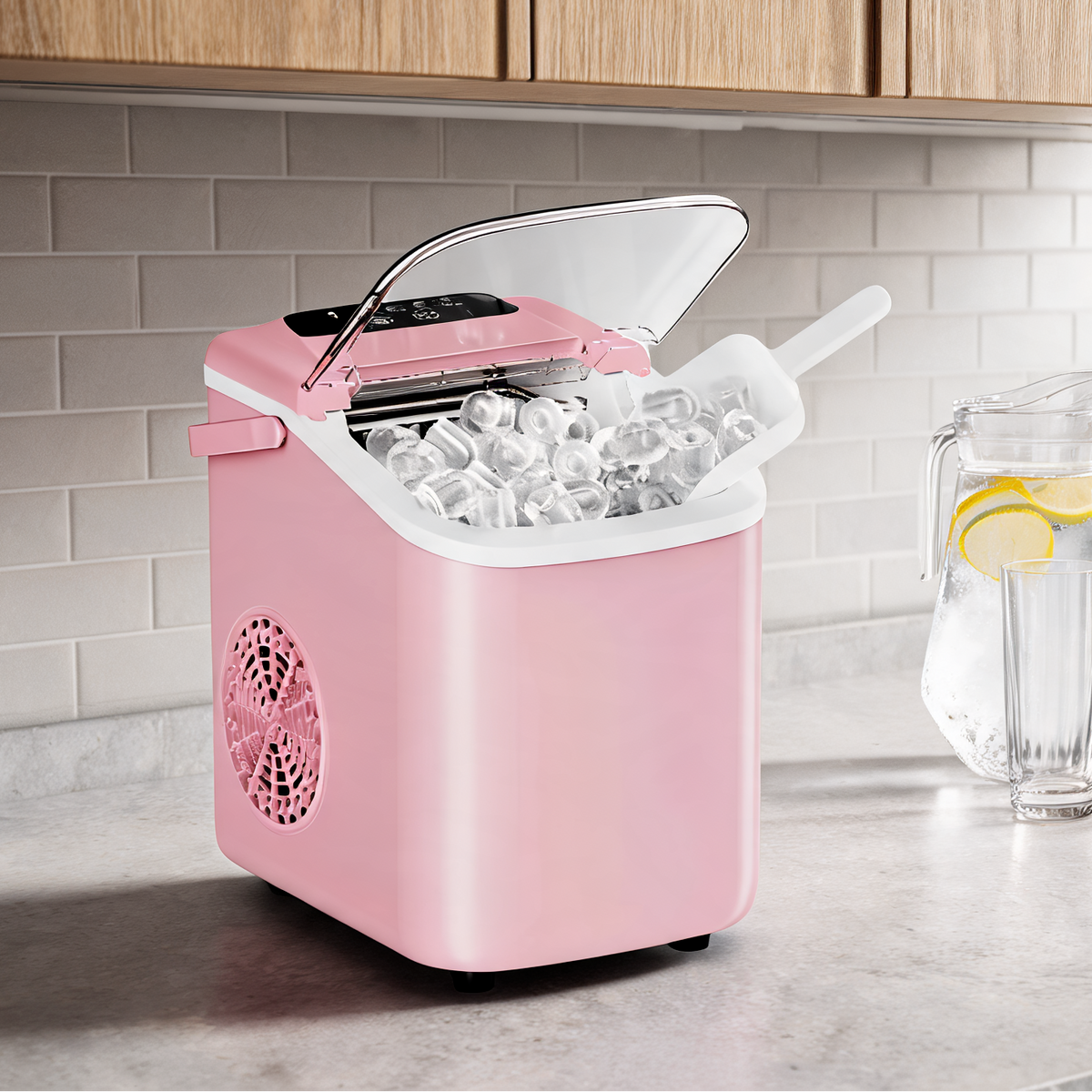 Pink ice machine on a white counter next to a pitcher of lemon water and stacked glasses