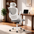 Gray mesh chair on a white frame with a headrest next to a wooden desk and a warm lamp