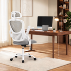 Gray mesh chair with a headrest pulled up to a wide wooden table with a monitor